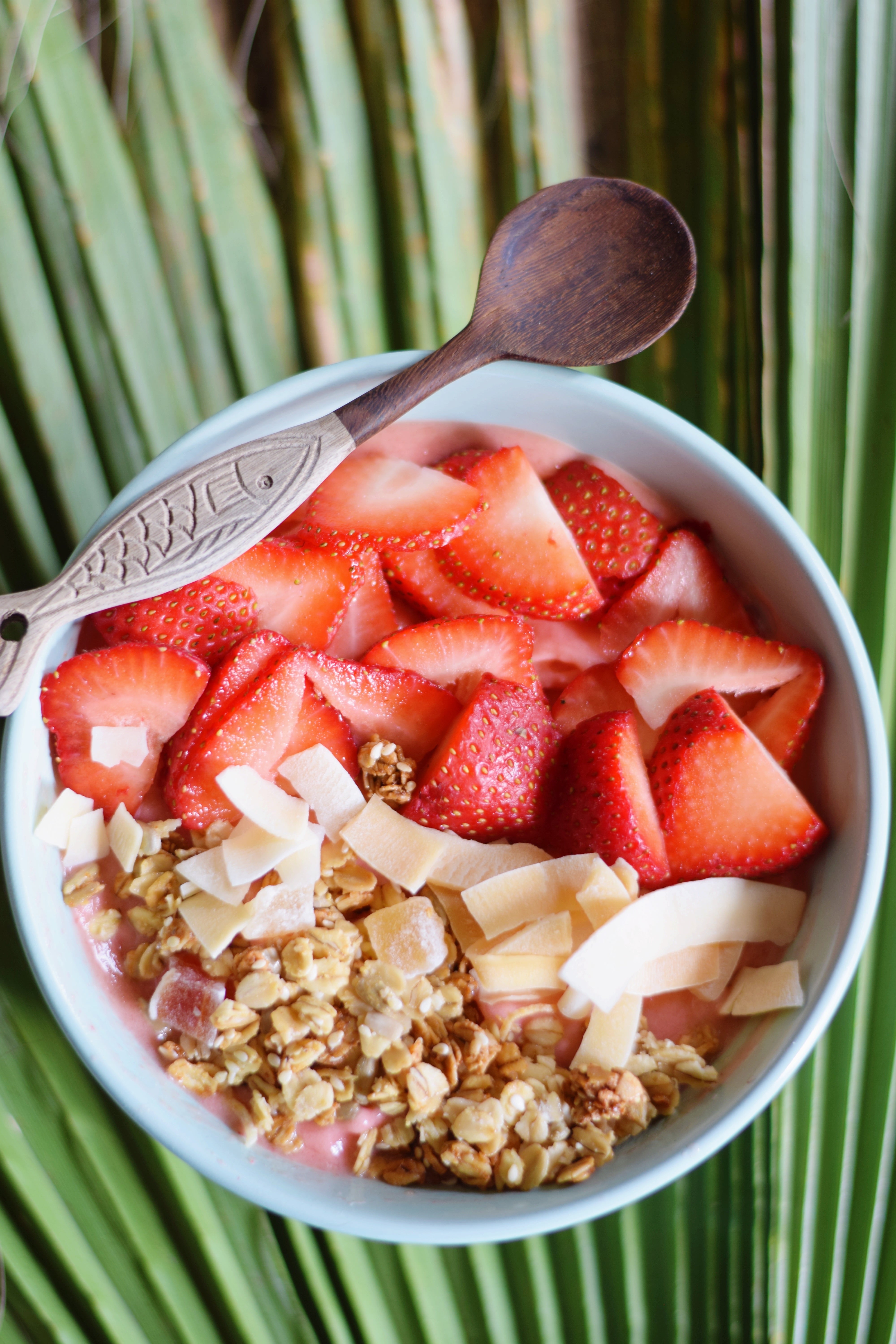Strawberry Mango Smoothie Bowl - Bowl of strawberries and frozen mangoes blended with frozen banana, macadamia nut milk and lime, topped with granola and coconut and fresh strawberries. 