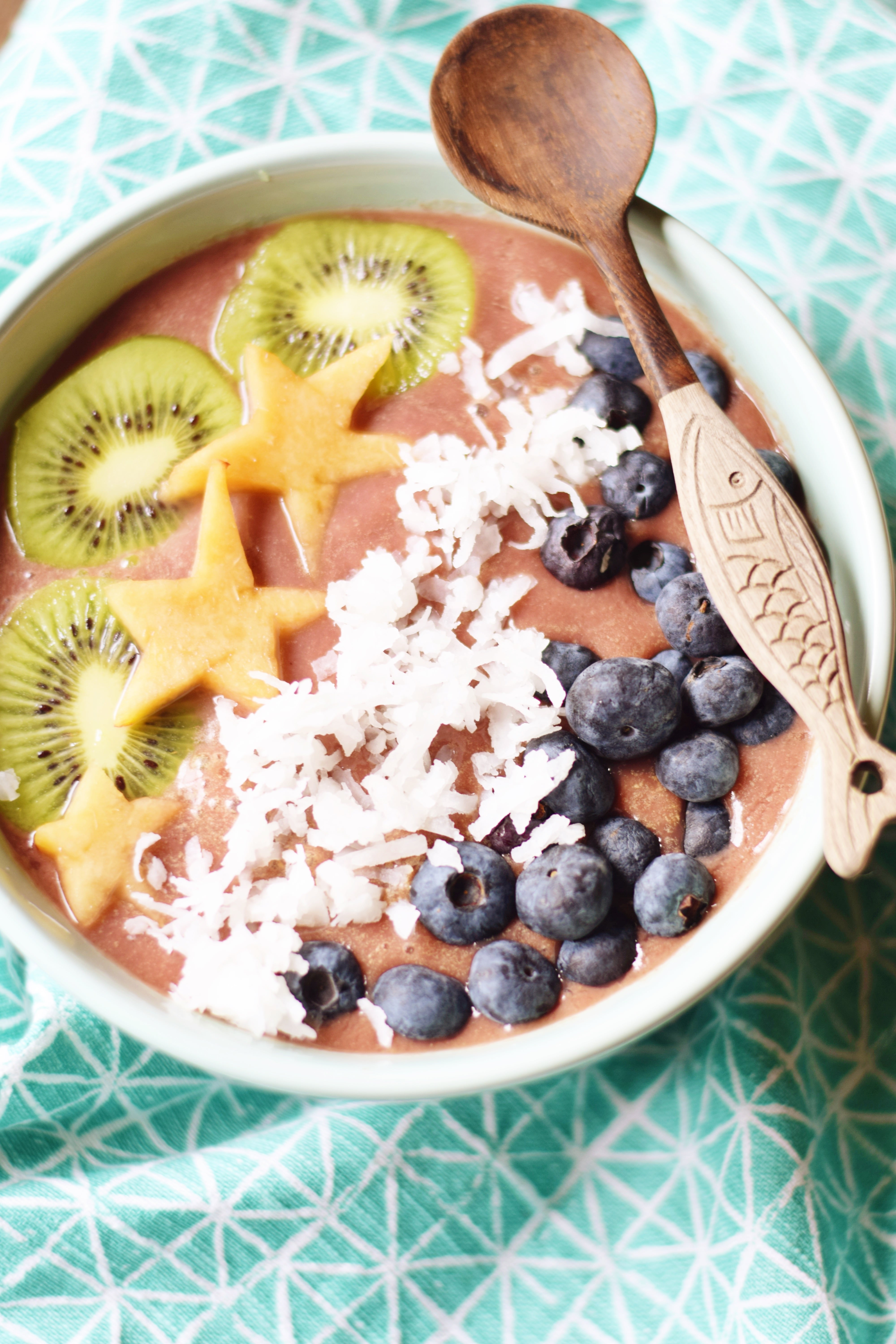Pineapple Acai bowl topped with kiwi, coconut, blueberries